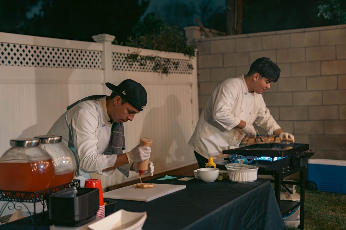 Isaac Huerta (Left) and Chris Villaseñor (Right) cooking and prepping the burgers before they go out to customers.
